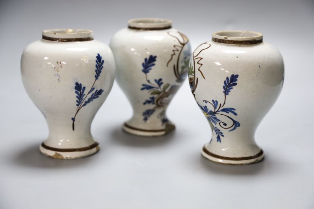 A set of three 19th century Dutch delft baluster jars, painted in colours, 14cm